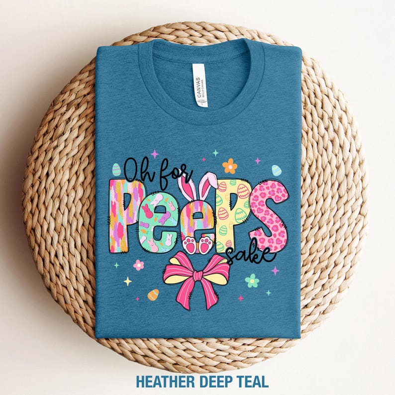 May include: A teal blue t-shirt with the text "Oh for Peep's sake" in colorful letters with a bunny and Easter egg design.