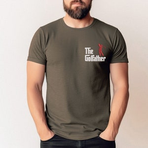 May include: A dark green t-shirt with a white graphic that says "The Golfather" with a red silhouette of a golfer swinging a club.