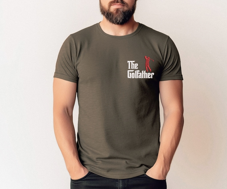 May include: A dark green t-shirt with a white graphic that says "The Golfather" with a red silhouette of a golfer swinging a club.