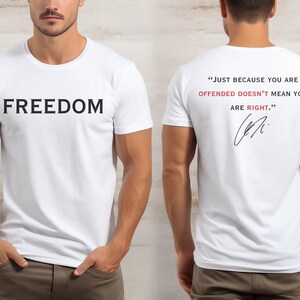 May include: White t-shirt with the word "FREEDOM" printed in black on the front. The back of the shirt features the quote, "JUST BECAUSE YOU ARE OFFENDED DOESN'T MEAN YOU ARE RIGHT." in red and black, with a signature.
