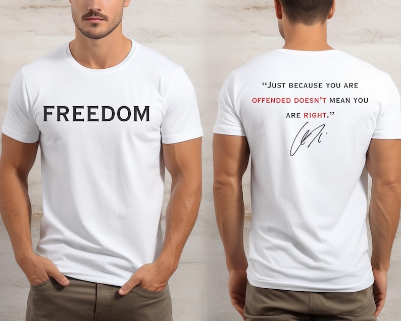 May include: White t-shirt with the word "FREEDOM" printed in black on the front. The back of the shirt features the quote, "JUST BECAUSE YOU ARE OFFENDED DOESN'T MEAN YOU ARE RIGHT." in red and black, with a signature.