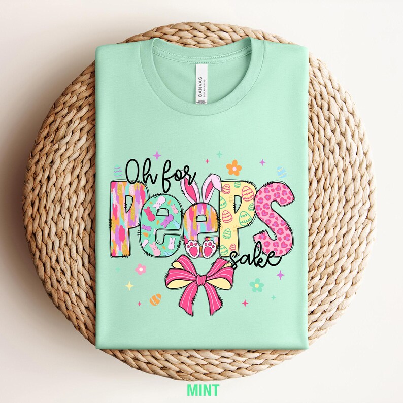 May include: A mint green t-shirt with a colorful graphic that says "Oh for Peeps sake". The graphic features a bunny, eggs, and a bow.