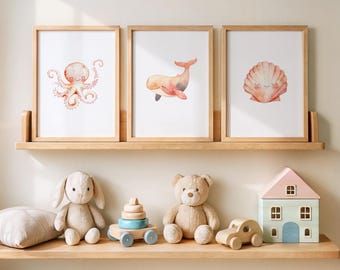 May include: Three framed watercolor prints of sea creatures: an octopus, a whale, and a seashell. Below, a wooden shelf displays a plush bunny, a teddy bear, a wooden stacking toy, a wooden car, a pillow, and a dollhouse.