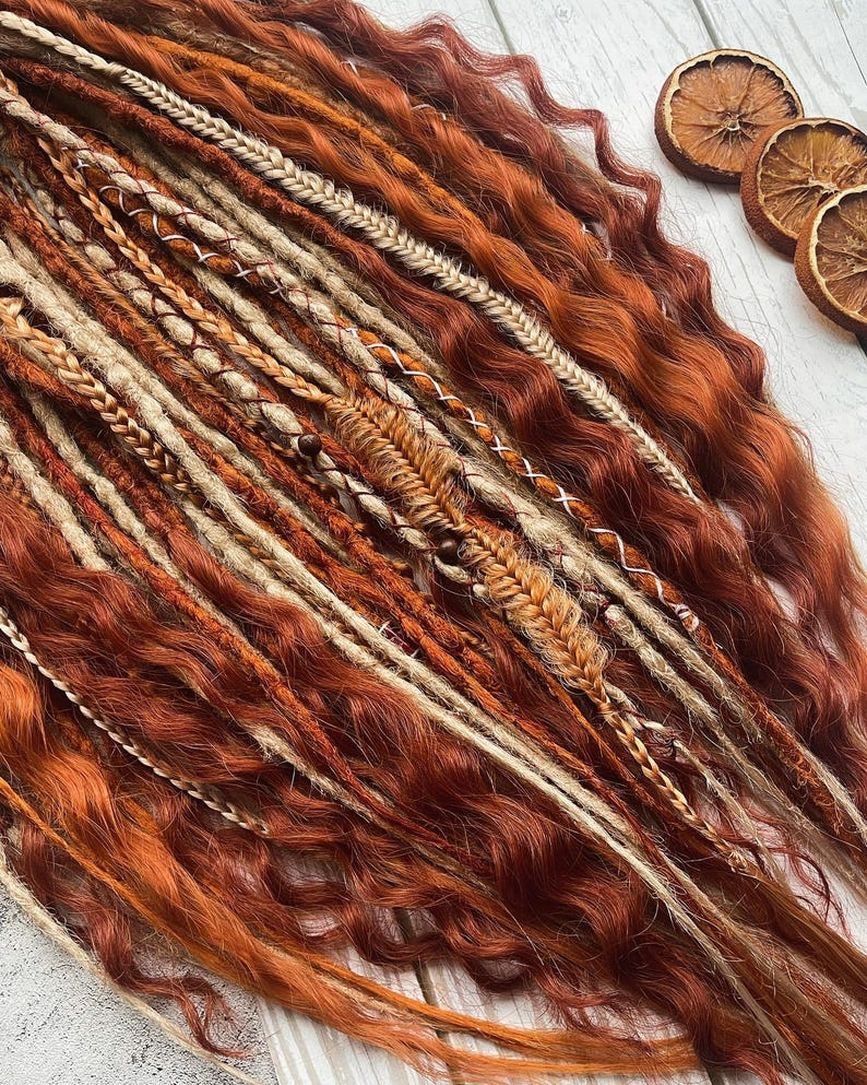 May include: A set of synthetic dreadlocks in shades of brown, beige, and blonde. The dreadlocks are long and wavy, with some featuring decorative beads and braiding.