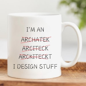 Puede incluir: Taza de cerámica blanca con texto negro que dice "Soy un Archatek, Arciteck, Arckiteckt Diseño cosas". Las palabras "Archatek", "Arciteck" y "Arckiteckt" están tachadas con líneas rojas.