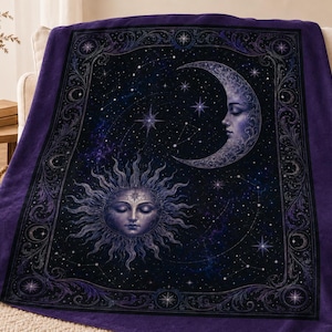 May include: A deep purple fleece blanket featuring a central celestial design of a sun with a human face and a crescent moon with a human face set against a dark starry night sky, all enclosed within an ornate, decorative rectangular border.