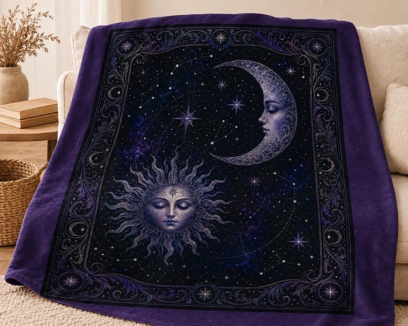 May include: A deep purple fleece blanket featuring a central celestial design of a sun with a human face and a crescent moon with a human face set against a dark starry night sky, all enclosed within an ornate, decorative rectangular border.