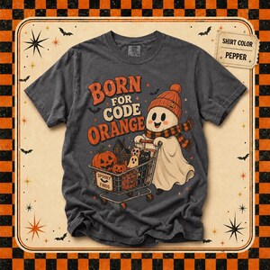 May include: A pepper-colored t-shirt featuring a graphic of a ghost wearing an orange beanie and scarf, pushing a shopping cart filled with pumpkins and a black cat. The text reads BORN FOR CODE ORANGE and SPOOKY FINDS on the cart.