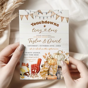 May include: Baby shower invitation with the text "Touchdowns & tiny toes" in a rustic design. The invitation features pumpkins, autumn leaves, and football-themed elements. The names Taylon & David are featured, along with the date and time.