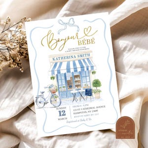 May include: A blue and white baby shower invitation with a gold script font that says "Bonjour Bébé". The invitation features a watercolor illustration of a blue and white striped awning over a storefront with a bicycle parked in front. The text on the invitation includes the date, time, location, and RSVP information.