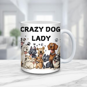 May include: White ceramic coffee mug with a black and white illustration of a group of dogs and the text "Crazy Dog Lady".