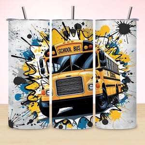Op de afbeelding: Een tumbler met een geel schoolbusontwerp met de woorden "SCHOOL BUS". De bus staat tegen een achtergrond van gele, blauwe en zwarte verfspatten. Een rietje is zichtbaar.