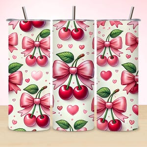 May include: A set of three stainless steel insulated tumblers with a repeating pattern of cherries, pink bows, green leaves, and pink hearts on a cream background. Each tumbler has a silver straw.