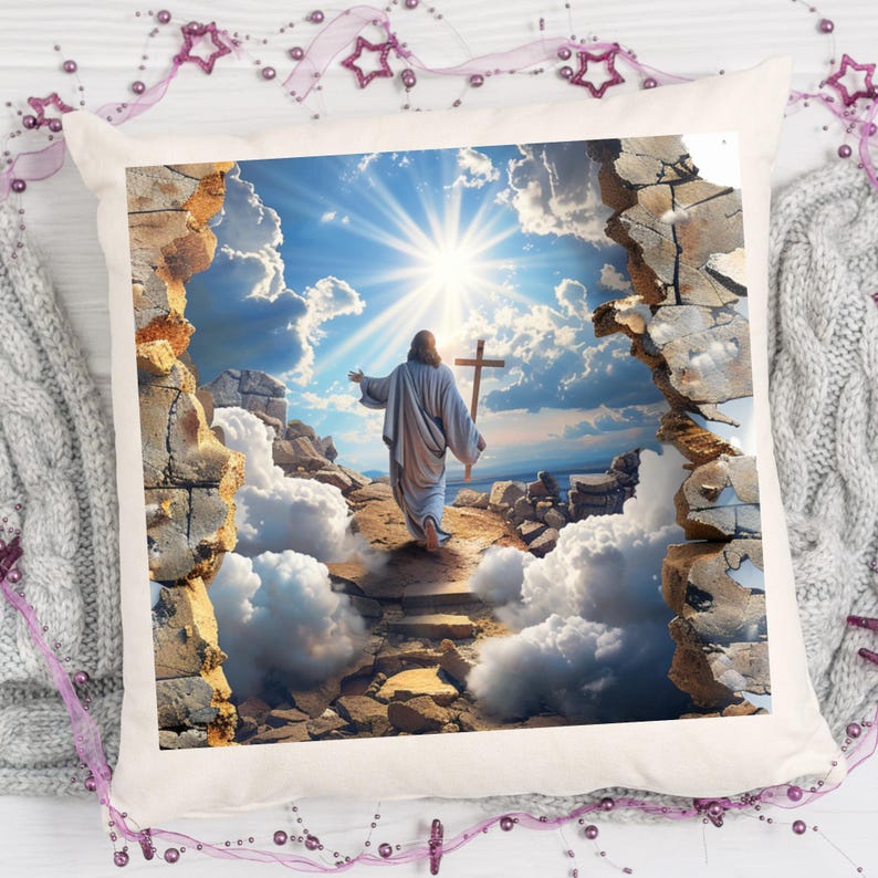 May include: A square throw pillow featuring a printed image of a figure in a robe walking toward a bright sunlit sky while holding a wooden cross. The scene is framed by a jagged, broken stone wall effect with clouds and rocky ground.