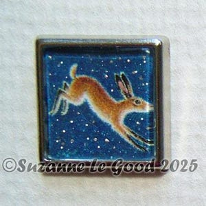 Könnte beinhalten: Ein quadratischer Harz-Cabochon mit silbernem Rahmen, auf blauem Hintergrund mit weißen Glitzer. Ein braunes Kaninchen springt über den Hintergrund.