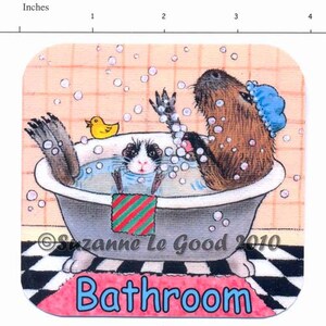 K&ouml;nnte beinhalten: Eine Cartoon-Illustration eines Capybaras und eines Meerschweinchens, die in einer Badewanne mit Blasen baden. Das Capybara tr&auml;gt eine blaue Duschhaube und das Meerschweinchen ein rot-gr&uuml;nes gestreiftes Handtuch. Der Text "Badezimmer" ist in blauen Buchstaben auf einem rosa Teppich geschrieben.