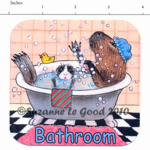 K&ouml;nnte beinhalten: Eine Cartoon-Illustration eines Capybaras und eines Meerschweinchens, die in einer Badewanne mit Blasen baden. Das Capybara tr&auml;gt eine blaue Duschhaube und das Meerschweinchen ein rot-gr&uuml;nes gestreiftes Handtuch. Der Text "Badezimmer" ist in blauen Buchstaben auf einem rosa Teppich geschrieben.