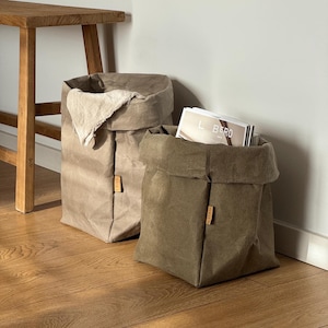 May include: A trio of ceramic mugs with a speckled, matte finish in cream, light grey, and dark grey. Each mug has a simple, modern design and a rounded handle. Suitable for tea or coffee, these mugs offer a minimalist aesthetic.