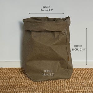 May include: An XXL size brown storage bag with a folded top edge. The bag features a width of 9.5 inches, a depth of 9.5 inches, and a height of 23.5 inches. The text XXL SIZE, WIDTH 9.5", HEIGHT 23.5", and DEPTH 9.5" is printed on the image.