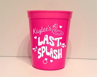 Peut inclure: Un gobelet en plastique rose vif avec l'inscription blanche "Kaylee's Last Splash". Le motif comprend un flamant rose, des cœurs et une bague. Le gobelet est cylindrique et semble vide.