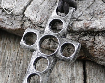 May include: A silver-toned metal cross pendant with a Celtic knot design. The cross has multiple circular cutouts throughout the design.
