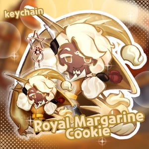 Op de afbeelding: Een sleutelhanger met een cartoonfiguur met cr&egrave;mekleurig haar, een zwart ooglapje en een gouden outfit. De tekst "Royal Margarine Cookie" en "keychain" zijn zichtbaar. De sleutelhanger heeft een ster-vormige bedel.