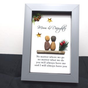 May include: A framed artwork featuring a pebble art design of two figures sitting on a piece of driftwood. The figures are labeled "Mum & Daughter" and the artwork includes the text "No matter where we go, no matter what we do, you will always have me and I will always have you".