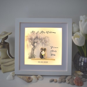 May include: A framed artwork with a white border. The image shows a tree illustration, two pebble figures embracing, and the text "Forever Starts Today." The date "30.06.2026" is also displayed.