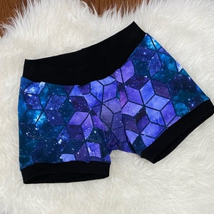 May include: Purple and blue geometric print shorts with a black waistband and black trim around the legs.