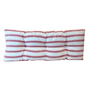 May include: A rectangular cushion featuring a red and white striped design. The cushion has a tufted construction, with the stripes aligned horizontally. The fabric seems to be woven, and the overall aesthetic is simple and traditional.