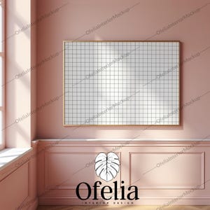 May include: A large, empty, white framed picture hanging on a pink wall with white trim. The frame is made of a thin, gold metal. The wall is painted a light pink color. The trim is white and has a slight raised edge. The picture is hanging in a room with a window to the left of the picture. The window is covered with a white curtain. The floor is made of wood. The picture is a grid pattern. The picture is a mockup for a product.