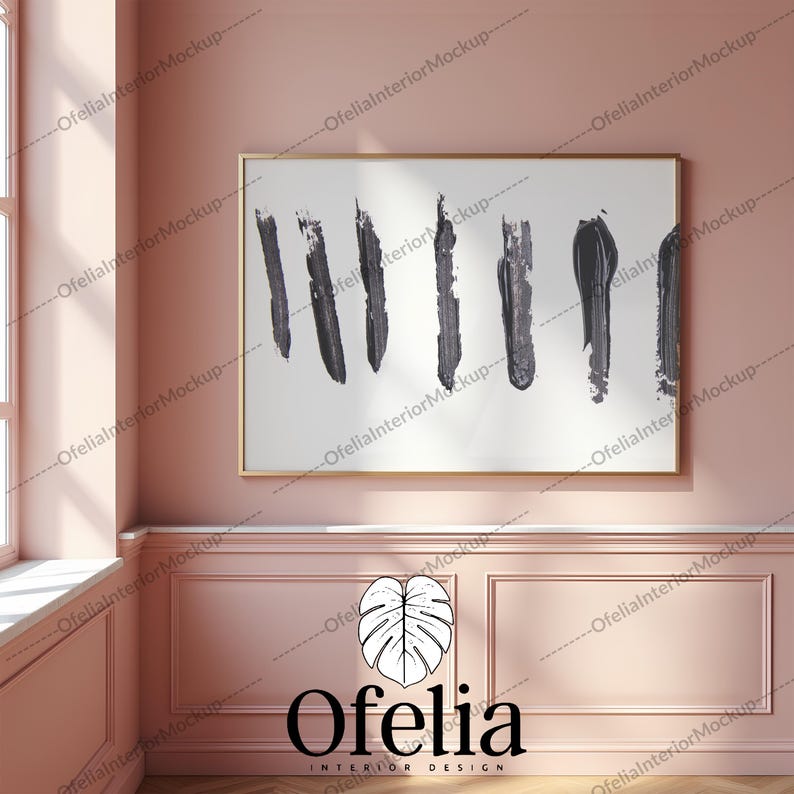 May include: A framed abstract painting with black brushstrokes on a white background. The frame is gold and the painting is hanging on a pink wall.
