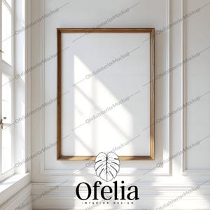 Può includere: Un muro bianco con una grande cornice in legno che circonda una tela bianca. La cornice ha una bordura dorata. Il muro è decorato con modanature bianche. L'immagine include il testo "Ofelia Interior Design".