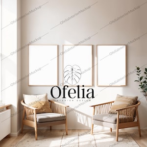 Könnte beinhalten: Drei gerahmte Drucke mit weißen Passepartouts und Holzrahmen hängen an einer weißen Wand. Der mittlere Druck zeigt eine Schwarzweißillustration eines Monstera-Blattes. Der Text "Ofelia Interior Design" befindet sich unter dem Druck. Zwei Stühle mit hellgrauen Kissen und Holzrahmen stehen vor den Drucken.