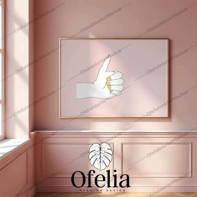 May include: A pink wall with a gold frame around a white drawing of a hand giving a thumbs up. The wall is decorated with white molding and a logo for Ofelia Interior Design featuring a green leaf.