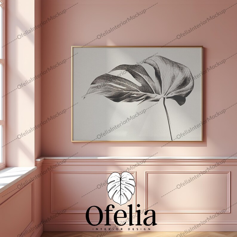May include: A framed black and white illustration of a large tropical leaf on a white background. The frame is gold and the illustration is hanging on a pink wall.