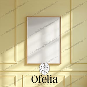 Può includere: Una cornice bianca con una cornice dorata è appesa a una parete gialla con una cornice bianca. La cornice è vuota e pronta per un'immagine o un'opera d'arte. La parete è testurizzata e ha una lucentezza sottile. La cornice è centrata sulla parete ed è circondata da un bordo bianco.