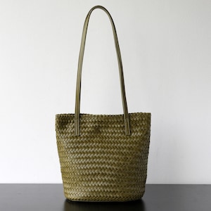 Peut inclure: Sac fourre-tout tiss&eacute; vert olive avec de longues anses. Le sac pr&eacute;sente un motif de tissage en forme de panier et est fabriqu&eacute; dans un mat&eacute;riau durable. Les anses sont de couleur vert olive assortie. Le sac est con&ccedil;u pour transporter des articles.
