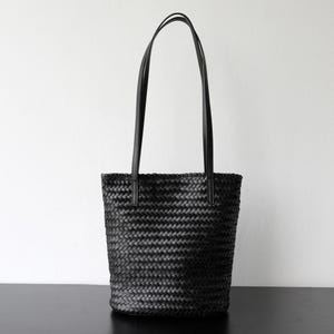 Peut inclure: Sac fourre-tout noir tiss&eacute; avec de longues anses fines. Le sac a une forme cylindrique et est fait d'un mat&eacute;riau tiss&eacute; serr&eacute;. Les anses sont fix&eacute;es en haut du sac et sont faites d'un mat&eacute;riau lisse et uni.