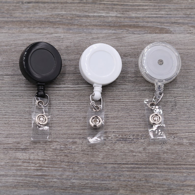 Puede incluir: Tres portagajes retr&aacute;ctiles, uno negro, uno blanco y uno transparente. Cada portagajes tiene una correa de pl&aacute;stico transparente y un clip de metal.