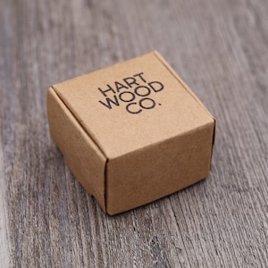 Puede incluir: Una peque&ntilde;a caja de cart&oacute;n marr&oacute;n con el texto "HART WOOD CO." impreso en la parte superior.