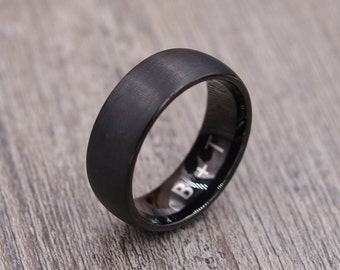May include: A black matte finish wedding band with a beveled edge and an inscription that reads "B+T".