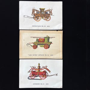 May include: Three vintage postcards featuring illustrations of antique fire engines. The postcards showcase detailed drawings of horse-drawn fire apparatus, each with unique designs and color schemes. The text on the cards includes the names and dates of the fire engines.