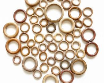 Set di 51 anelli in legno per esporre palline, uova, pietre e oggetti artigianali.