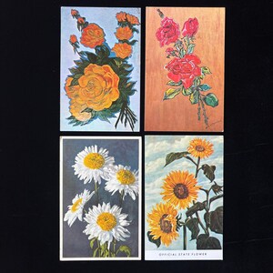 May include: Four vintage floral postcards. One features orange roses, another red roses, a third white daisies, and the last sunflowers with the text "OFFICIAL STATE FLOWER". Each card has a different background.