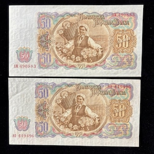 May include: Two vintage Bulgarian 50 Leva banknotes. Each bill features a woman in traditional attire holding baskets of flowers. The text "БЪЛГАРСКА НАРОДНА БАНКА" is visible, along with the year 1971 and serial numbers.