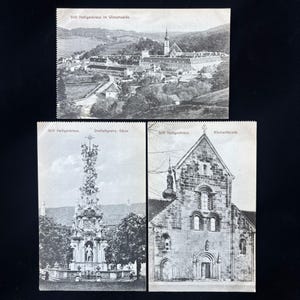 May include: Three black and white vintage postcards featuring Stift Heiligenkreuz. The top card shows a landscape view with the text Stift Heiligenkreuz im Wienerwalde. The bottom left shows a column with text Stift Heiligenkreuz. Dreifaltigkeits-Säule. The bottom right shows a church facade with text Stift Heiligenkreuz. Kirchenfacade.