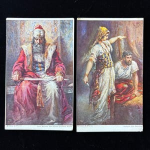 Könnte beinhalten: Zwei Vintage-Postkarten mit biblischen Szenen. Eine zeigt einen Mann in roten Gewändern mit einem Schwert, die andere eine Frau, die auf einen sitzenden Mann zeigt. Die Texte lauten "SAUL BROODS AND PLOTS AGAINST DAVID" und "SAMSON AND DELILAH".