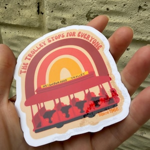 May include: A sticker featuring a red trolley with the text "The Trolley Stops for Everyone" above a rainbow design. The sticker also includes the text "Neighborhood Trolley" and "Since 1968".
