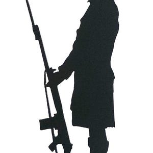 Op de afbeelding: Zwart metalen silhouet van een persoon die een geweer vasthoudt, staand op een cirkelvormige basis. De figuur draagt een hoed en een lange jas. Het geweer is gedetailleerd met een lange loop en een magazijn.